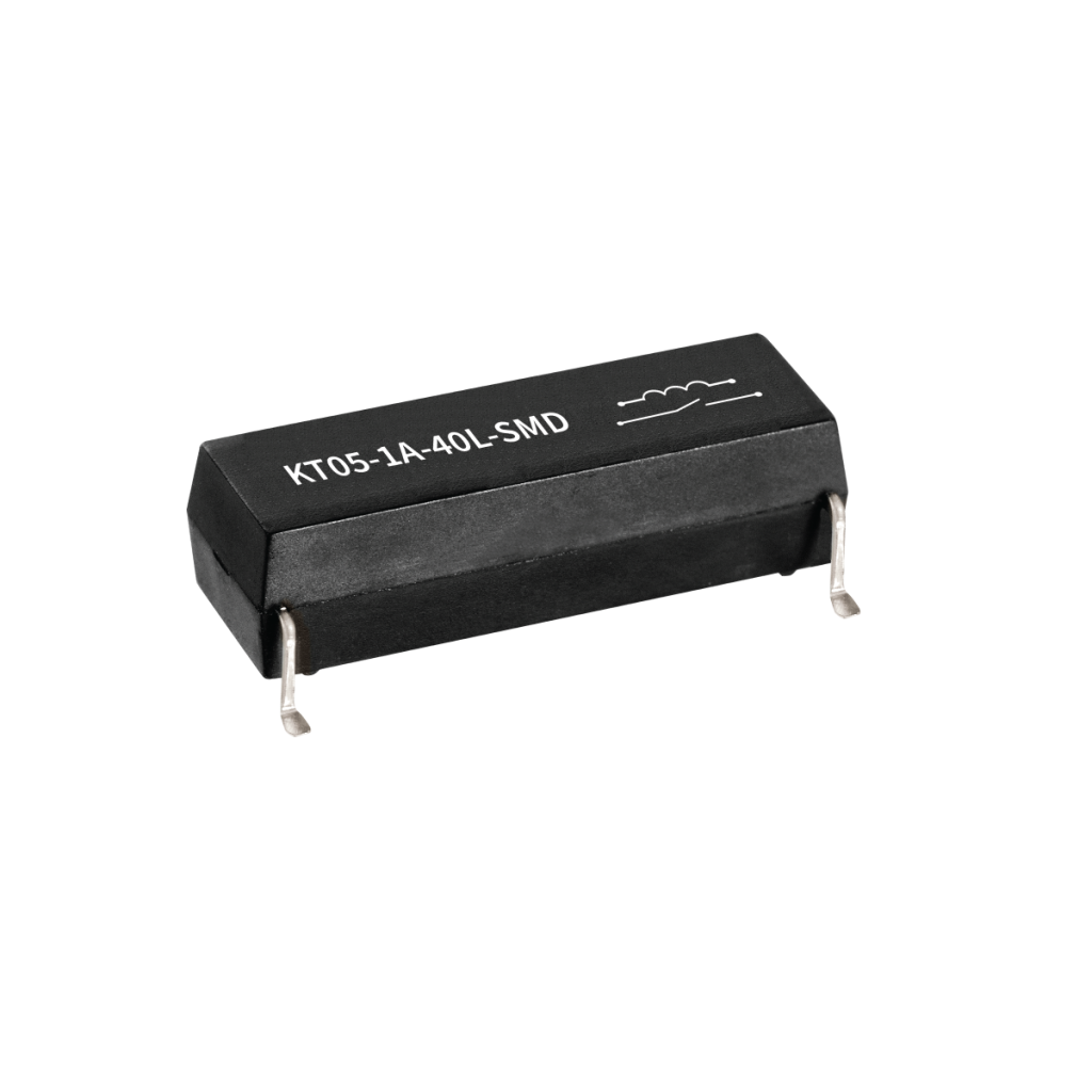 A black rectangular KT Series Reed Relay, labeled KT05-1A-40L-SMD, features four metal pins for surface mounting, photographed on a white background. by Standex Detect
